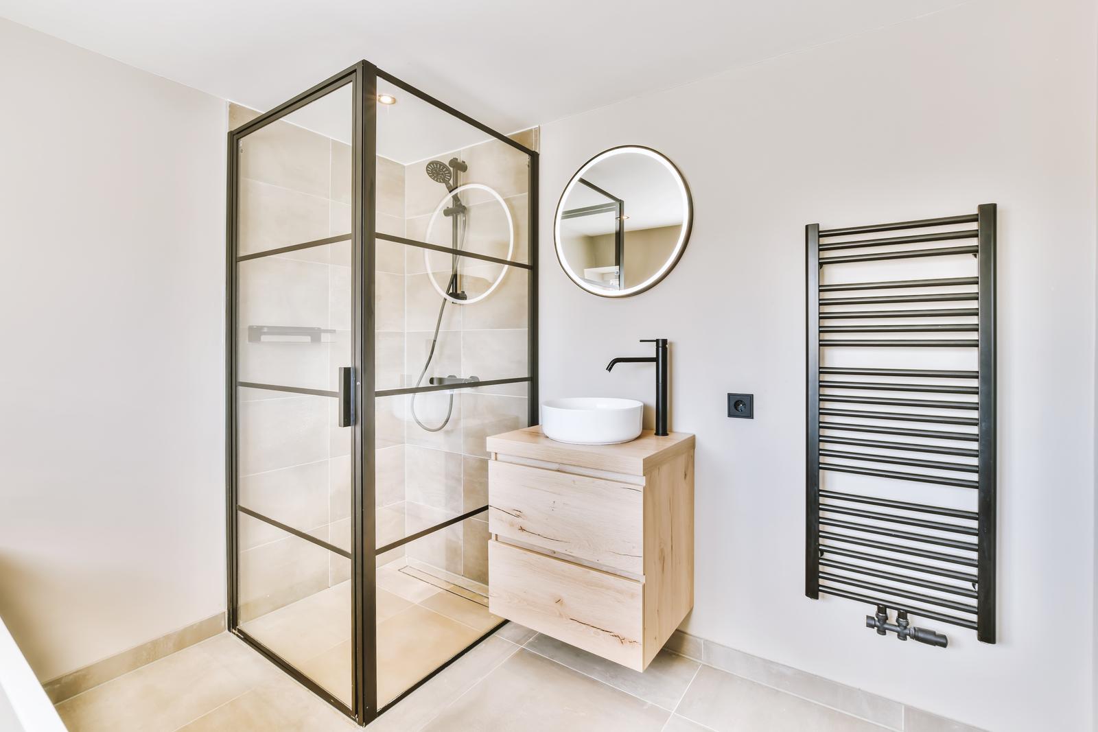 Delightful minimalist bathroom with illuminated round mirror